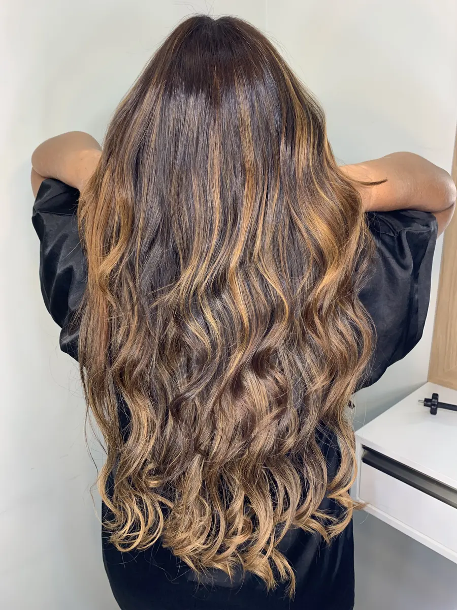 Mechas caramelo em cabelo ondulado feitas no Mutari em Maceió